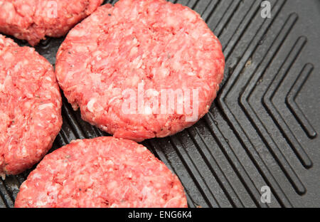 Rohe Burger auf Metall grriddle Stockfoto