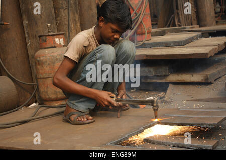 Eine junge schneiden Eisenplatte mit Gas niedlicher am Dolaikhal in Dhaka, Bangladesh.March 22, 2013. Stockfoto