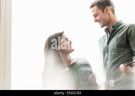 Ein Mann und eine Frau im Gespräch bei einem Kaffee in einem Büro. Stockfoto