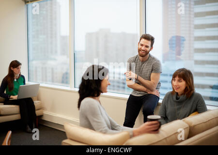 Drei Personen an einem Fenster in ein Büro, zwei Frauen und ein Mann. Stockfoto