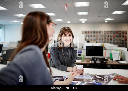 Zwei Frauen sitzen in einem Büro reden und lachen. Stockfoto