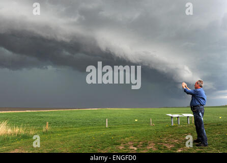 Wremen, Deutschland. 5. Mai 2015. Ein Fußgänger Fotografien der aufstrebenden Gewitterfront am Siel Hafen in Wremen, Deutschland, 5. Mai 2015. Eine schwerer Sturm-Front brachte Donner, Blitze und Regen am Nachmittag. Foto: INGO WAGNER/Dpa/Alamy Live News Stockfoto