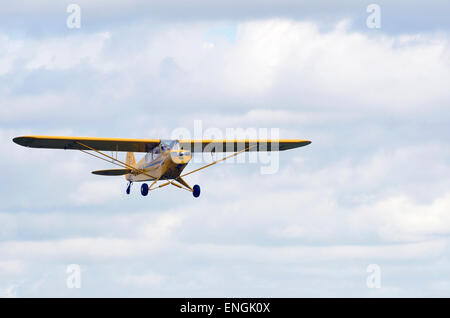 Einen klassischen Leichtflugzeug - Piper PA18 Super Cub G-AMEN klettert vom Popham Flugplatz im Mai 2015. Stockfoto