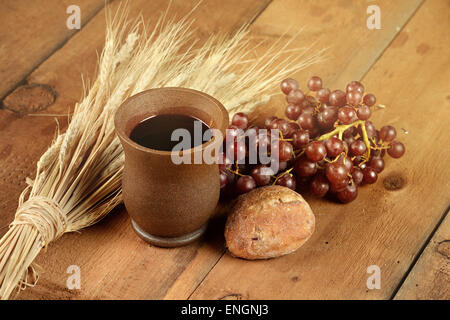 Kommunion-Elemente mit Wein und Brot auf Holztisch Stockfoto