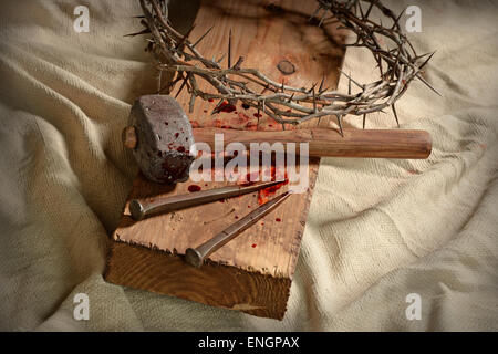 Dornenkrone, Nägel und Hammer am Holzkreuz Stockfoto