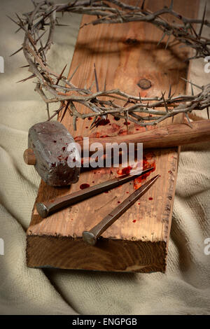 Kreuz mit Dornenkrone, Nägel und hammer über alten Tuch Stockfoto