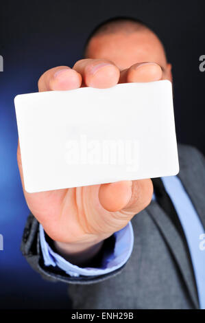 ein junger kaukasischer Mann trägt einen grauen Anzug hält eine leere Schild in der hand Stockfoto