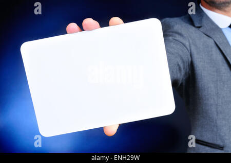 ein junger kaukasischer Mann trägt einen grauen Anzug hält eine leere Schild in der hand Stockfoto