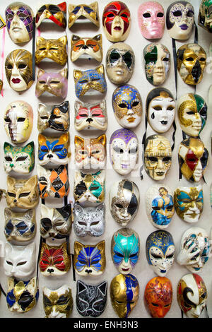 Voll von schönen eleganten traditionellen venezianische Masken sind auf Wand für Straßenkarneval in Venedig gehängt Stockfoto