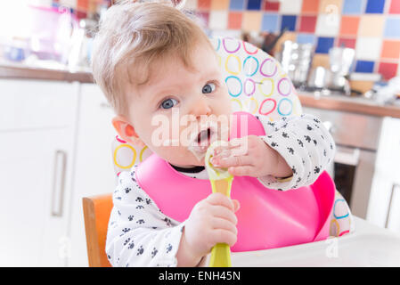 Sechs Monate altes Baby Mädchen Löffel Fütterung auf Brei Stockfoto