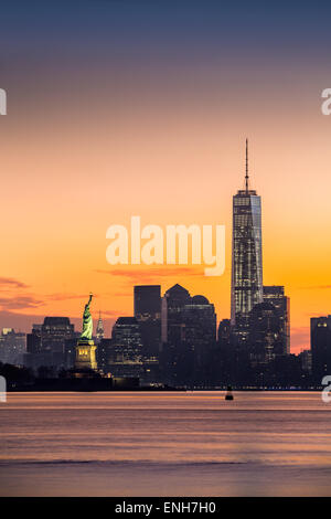 Lower Manhattan mit Freedom Tower und The Statue of Liberty bei Sonnenaufgang Stockfoto