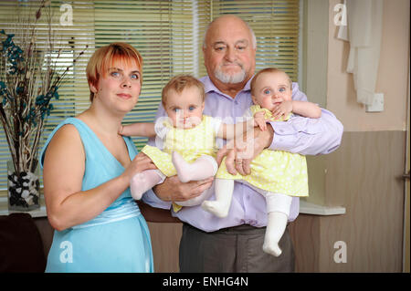 Großbritanniens älteste Vater von Zwillingen Richard Roden (71) mit seiner Frau Lisa (25) und ihre eineiige Zwillinge Ruby(L) und Emily(R) Stockfoto