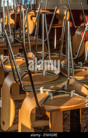 Stühle und Tische gestapelt in einem geschlossenen Restaurant. Stockfoto