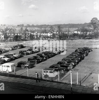 Historische Reihen von Automobilen der 1950er Jahre, die auf einem Stück leerem Vorstadtland, London, England, Großbritannien, geparkt waren. Stockfoto