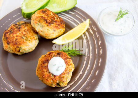 Thai Fisch Kuchen mit weißer Sauce, Dill und Zitrone auf Platte Stockfoto