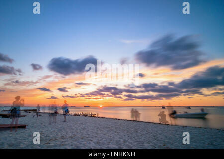 Isla Mujeres, Mexiko - 24. April 2014: Sonnenuntergang Langzeitbelichtung mit Strand, Boote und Touristen am berühmten Strand von Playa del Norte in ist
