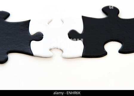 schwarze und weiße Puzzleteile kontrastierenden Stockfoto