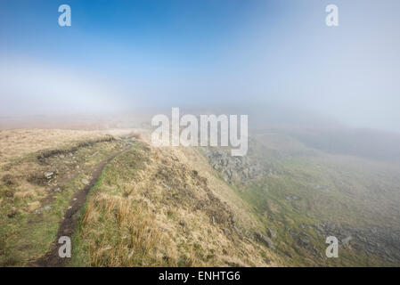 Cracken Sie Rand in der Nähe von Chinley in Derbyshire auf eine atmosphärische, nebligen Morgen im Frühling. Spuren der Fogbow im Nebel. Stockfoto