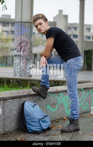 Attraktiver junger Mann mit Rucksack draußen Stockfoto