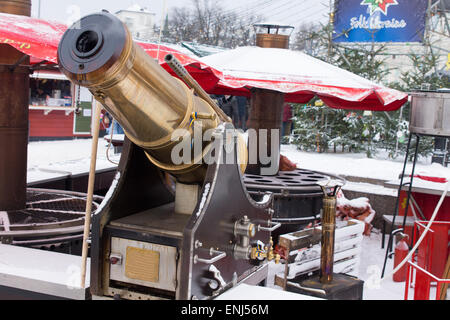 Nahaufnahme von Messing Wasserwerfer im Freien im Winter mit roten Patioregenschirme im Hintergrund Stockfoto