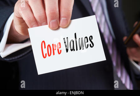 Ein Geschäftsmann hält eine Visitenkarte mit den Worten, Grundwerte, darauf geschrieben. Stockfoto