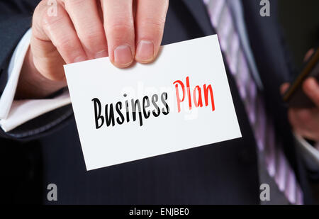 Ein Geschäftsmann hält eine Visitenkarte mit den Worten: Business Plan, darauf geschrieben. Stockfoto