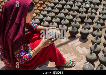 Bhaktapur, Nepal - vom 20. März 2015: Frau Inverkehrbringen Töpfereien zum Trocknen auf Keramik Platz. Stockfoto