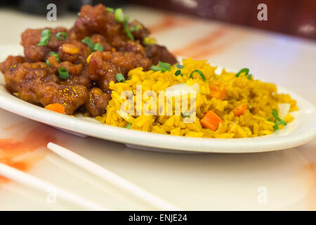 Scharf und würzig General Tso Huhn serviert mit einer Seitenlänge von Schweinefleisch gebraten Reis Stockfoto