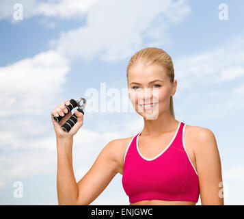 lächelnde Frau mit Hand expander Stockfoto