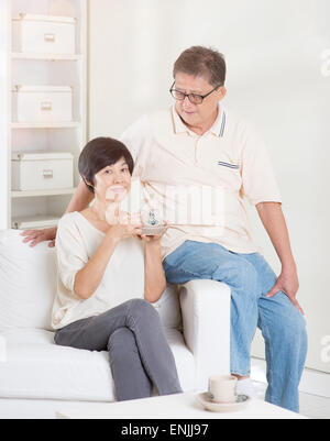 Älteres Paar mit Tee und entspannen, sitzen auf dem Sofa zu Hause. Lebendige Lebensweise der asiatischen Familie. Stockfoto