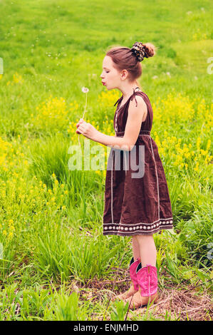 Mädchen im Land Wiese weht auf Löwenzahn Stockfoto