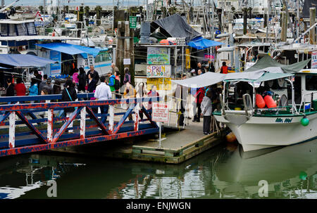 Käufer und Verkäufer von frischen Meeresfrüchten aus der Angelboote/Fischerboote in Steveston Village, British Columbia, Kanada.  Am Fishermans Wharf. Stockfoto