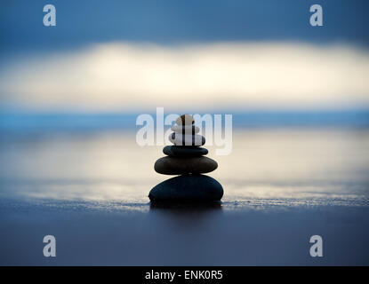 Kiesel, balancieren auf einem stürmischen Strand im frühen Morgenlicht. Selektiven Fokus Stockfoto