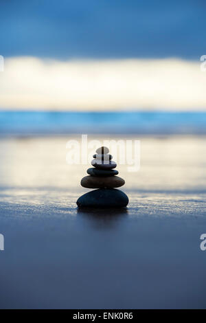 Kiesel, balancieren auf einem stürmischen Strand im frühen Morgenlicht. Selektiven Fokus Stockfoto