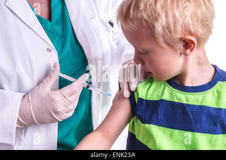 kleiner Junge eine Injektion gegeben, durch den Hausarzt. Die Ärztin bietet dem Kind eine Injektion in den Oberarm. Es kann sein, b Stockfoto