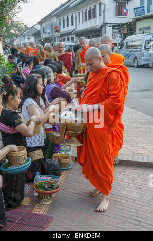 LUANG PRABANG, LAOS - 19. Februar 2011: Unbekannter Mönche Fuß zum Sammeln von Almosen und Angebote am 19. Februar 2011. Stockfoto