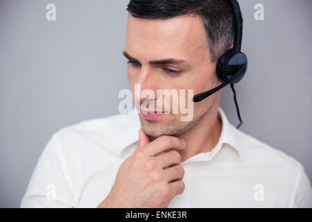 Porträt eines männlichen nachdenklich Betreibers über grauen Hintergrund Stockfoto