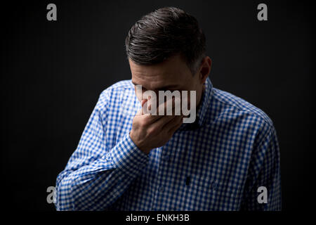 Mann für den Mund mit Händen auf schwarzem Hintergrund Stockfoto