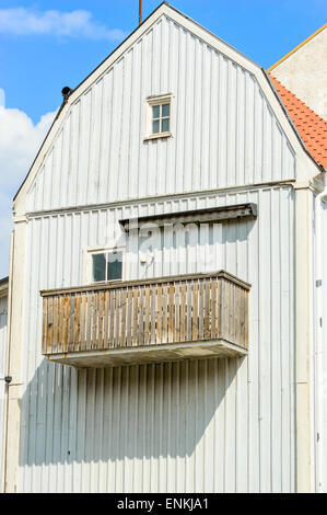 Unbemalte alte Balkon auf graue Holzhaus mit kleinen Fenstern. Stockfoto