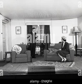 1950er Jahre, historische Amateurdramatiker, zwei Schauspieler, ein Mann und eine Frau auf einer Bühne, die als Vorzimmer eines Hauses in einem Theaterstück spielt, Oxford, England, Großbritannien. Amateurtheater war eine beliebte Freizeitbeschäftigung in Großbritannien in dieser Zeit. Stockfoto