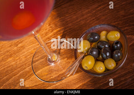 Frucht-Cocktail und eine Schüssel mit Oliven auf einen Balken Stockfoto