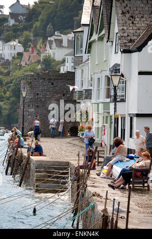 Die Menschen Sie saßen und entspannend in Bayard Cove, Dartmouth. Familien fangen Krabben auf der Hafenmauer. Stockfoto