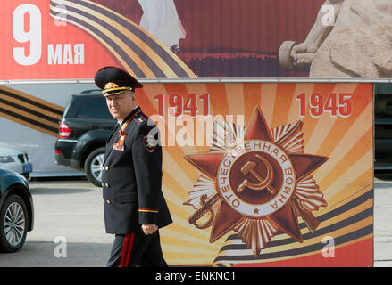 Wolgograd, Russland. 7. Mai 2015. Eine russische Offiziere der Armee geht vorbei an einem Plakat für den 70. Jahrestag des Endes des zweiten Weltkriegs auf dem Flughafen in Wolgograd, Russland, 7. Mai 2015. Deutsch Foreign Minister Frank-Walter Steinmeier und sein russischer Amtskollege Sergej Lawrow Gedenken zum 70. Jahrestag des Endes des zweiten Weltkriegs in Europa in ehemals Stalingrad. Foto: SOEREN STACHE/Dpa/Alamy Live News Stockfoto