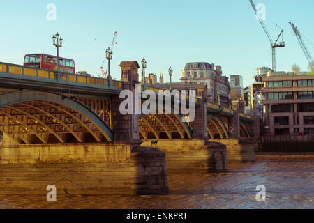 Southwark Bridge an einem Sommerabend mit einem roten Londoner Bus gehen darüber Stockfoto