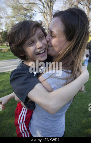 Zehn Jahre alten Jungen mit einer liebevollen Moment mit seiner Mutter. Stockfoto