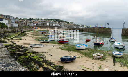 Kornische Fischen Dorf Mousehole mit seinem hübschen Hafen bei Ebbe, wenn die Fischerboote gestrandet sind. Stockfoto