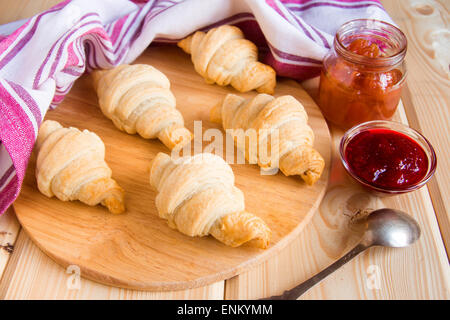 Hausgemachte frische Croissants mit Marmelade (Marmelade) auf Holztisch Stockfoto