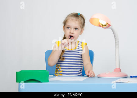 Vierjährige Mädchen Europäer zieht Bleistift auf einem Blatt, am Tisch sitzen Stockfoto