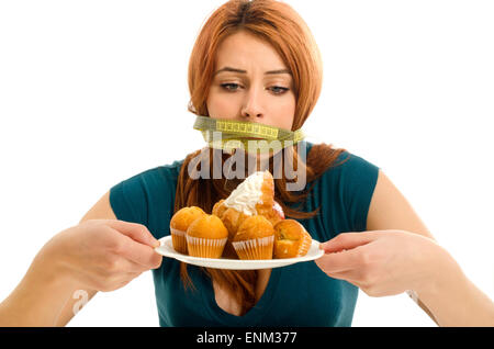 Frau mit einem Zentimeter auf den Mund nicht in der Lage, alle Süßigkeiten und Zucker, viel Cookies auf einem Teller zu essen. Eine Diät ohne Süßigkeiten Stockfoto