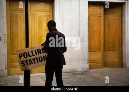 Hackney, London, UK. 7. Mai 2015. Nach einem langen Tag der Abstimmung über die das Land bei den Parlamentswahlen die Wahllokale schließen. Ein Wahllokal Offizier in Hackney Town Hall kuppelt die Beschilderung kurz nach 22:00 Credit: Kristian Buus/Alamy Live News Stockfoto